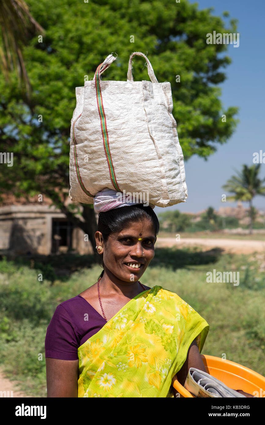 India, Karnataka, Hampi, local woman carries load on the head Stock Photo