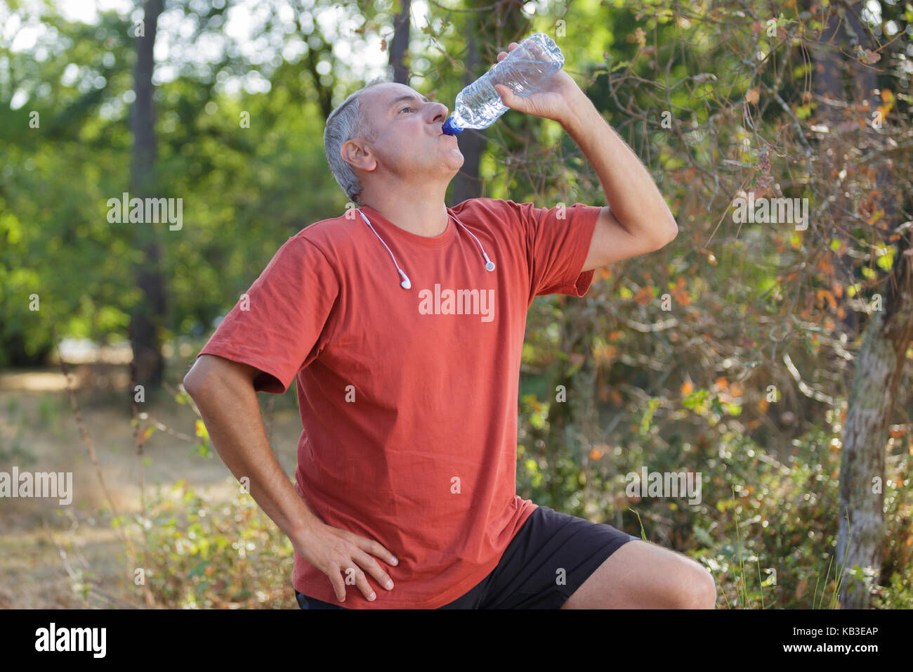 senior man is drinking water after workout in park Stock Photo - Alamy