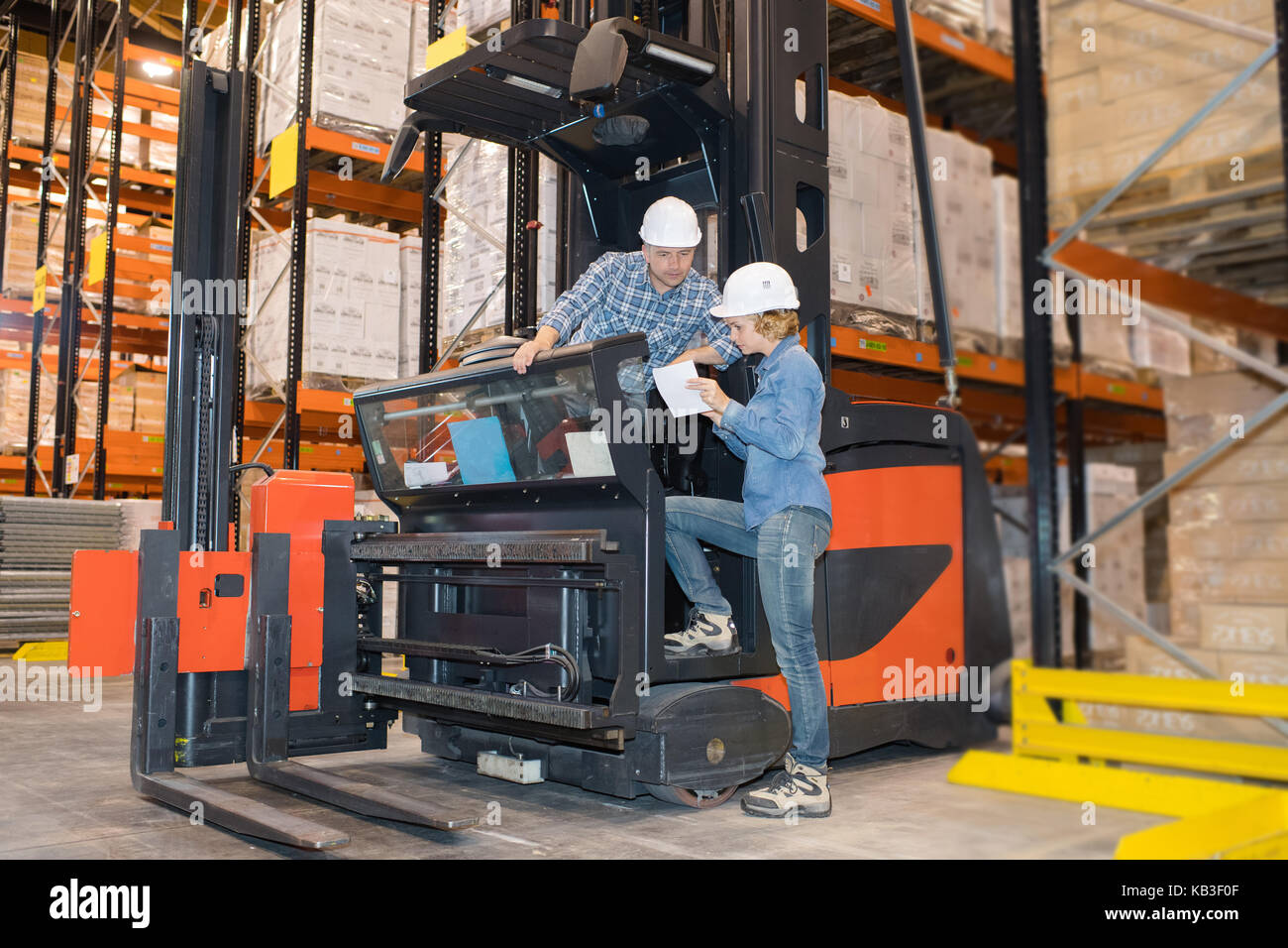 driver on forklift truck transporting from packaging machine to warehouse Stock Photo