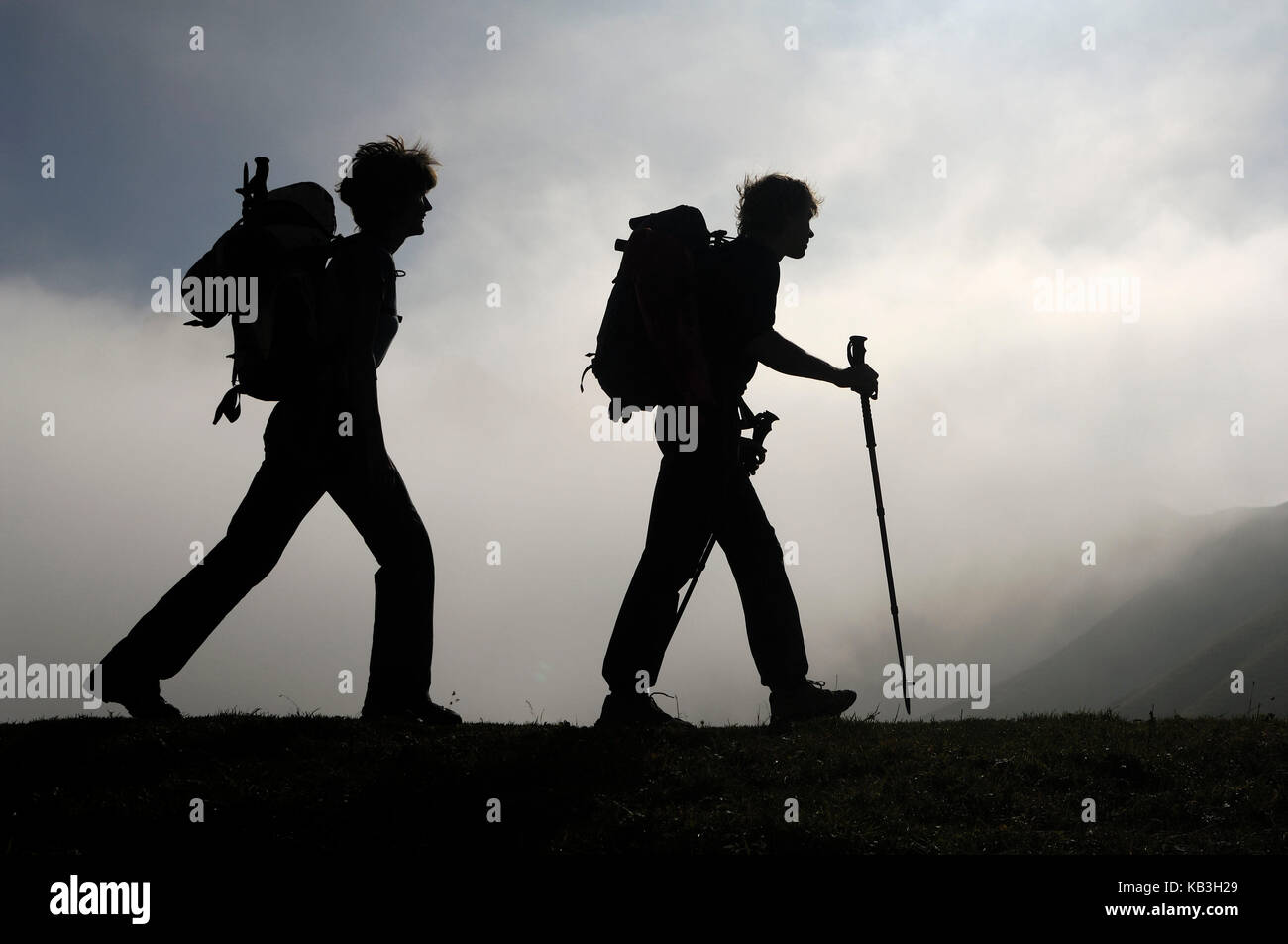 Two hikers in the silhouette Stock Photo - Alamy