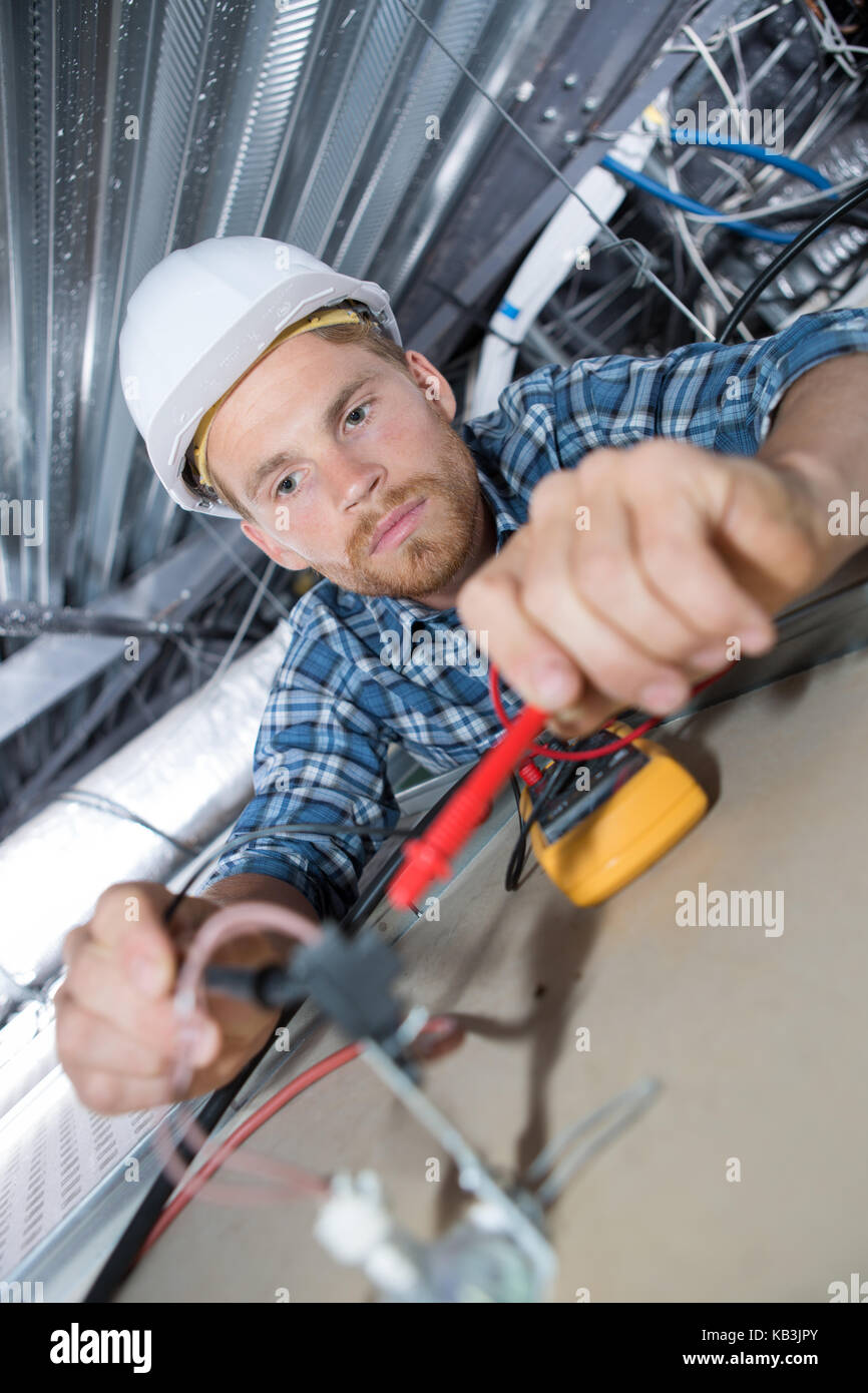 male electrician fixing cables for a light on ceiling Stock Photo Alamy
