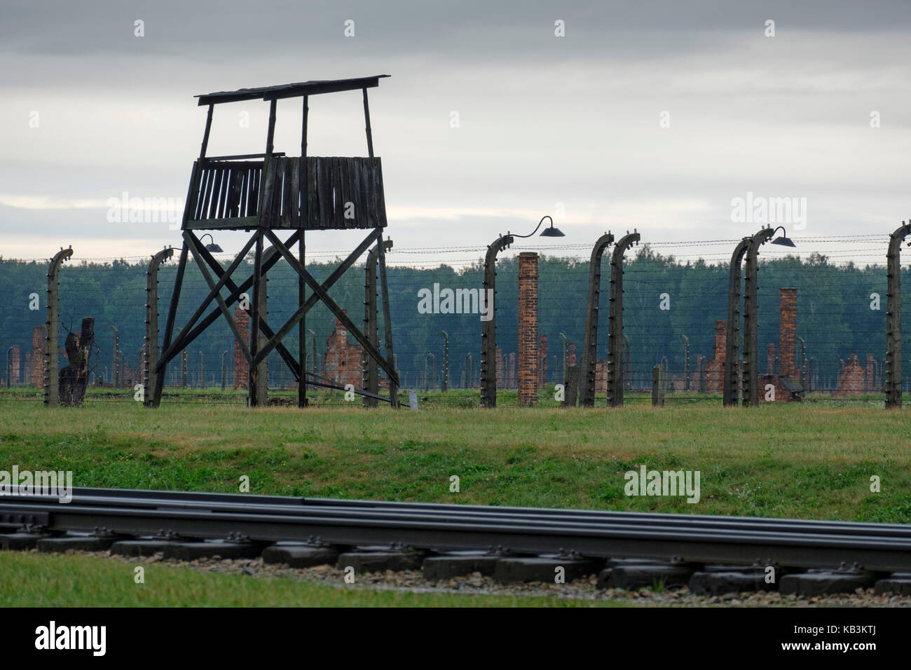 Watchtower and barbwire fences at Auschwitz II Birkenau concentration camp, Poland Stock Photo