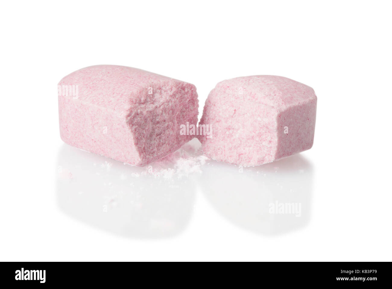 A pink pill that has been cut in half expensive medication concept