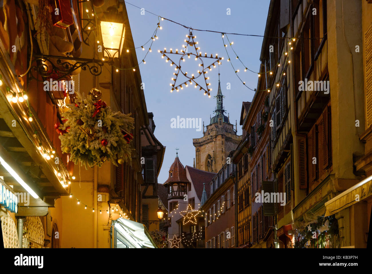 France, Haut Rhin, Colmar, Christmas decoration at Rue des Marchands, Maison Pfister and steeple of Saint Martin's Abbey Church Stock Photo