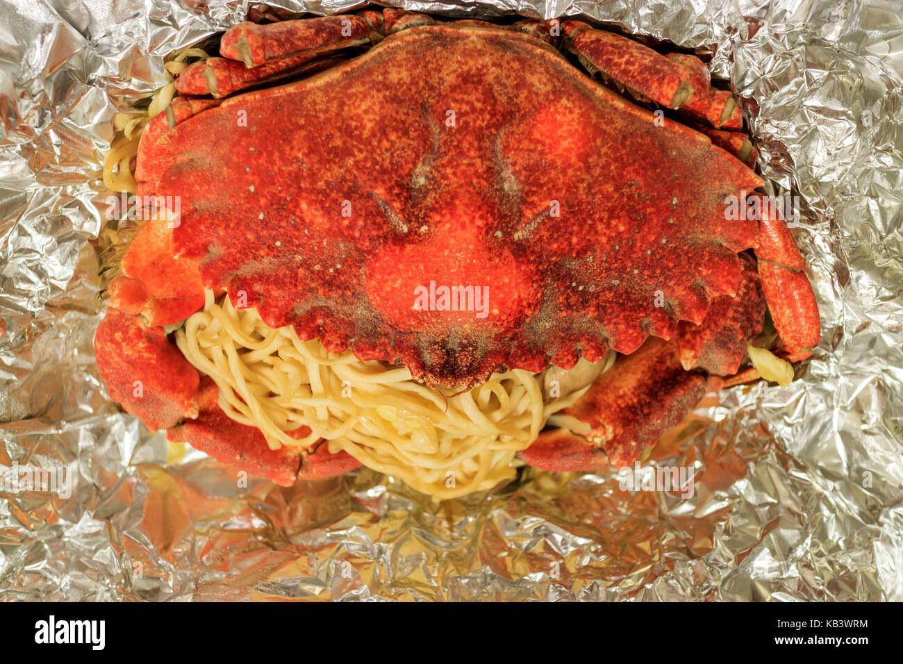 Stone crab prepared in aluminum foil with noodle at home, Los Angeles, California, United States Stock Photo