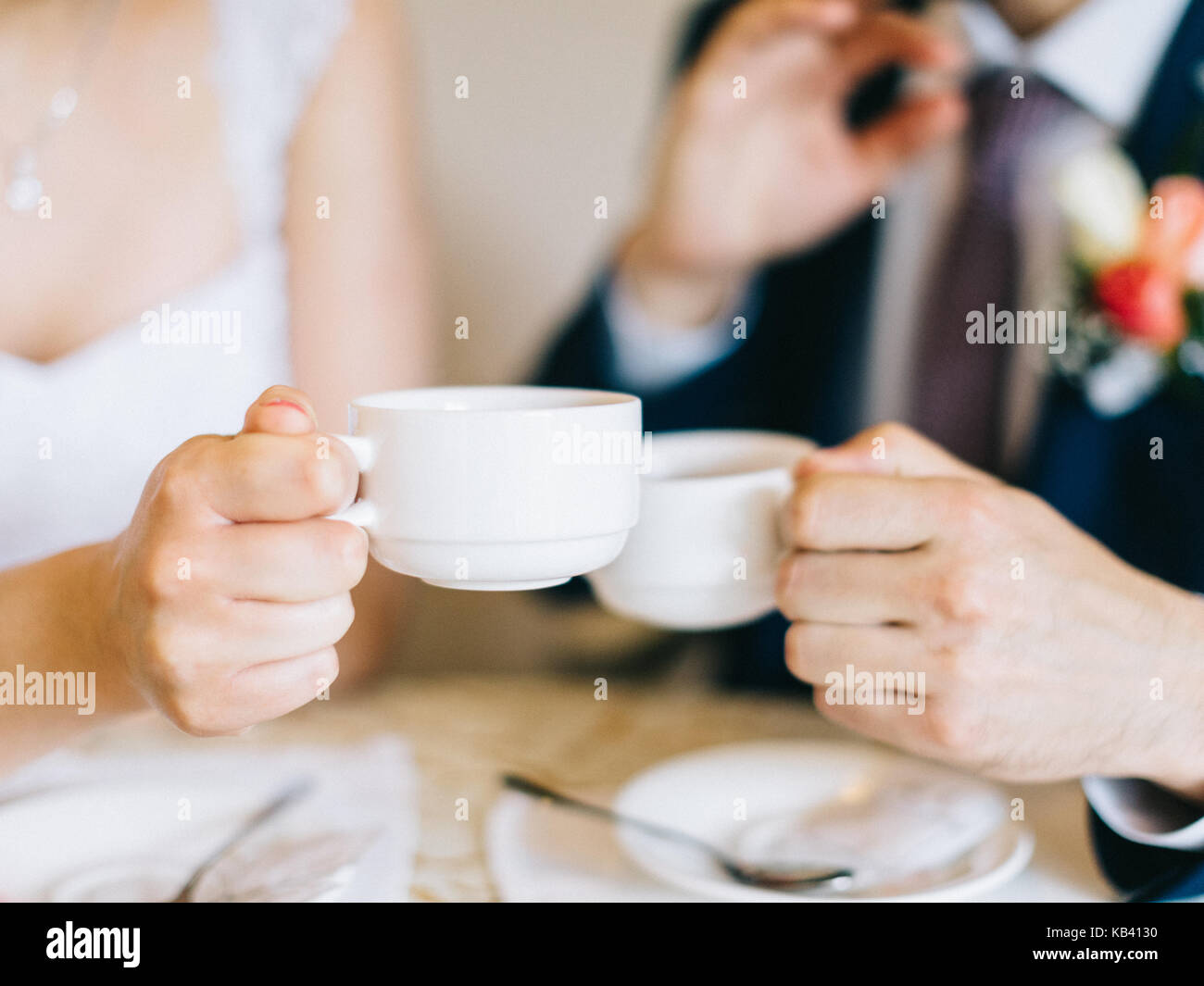 Groom and bride holding coffee cup. Cups of coffee for bride and groom at  wedding day Stock Photo - Alamy