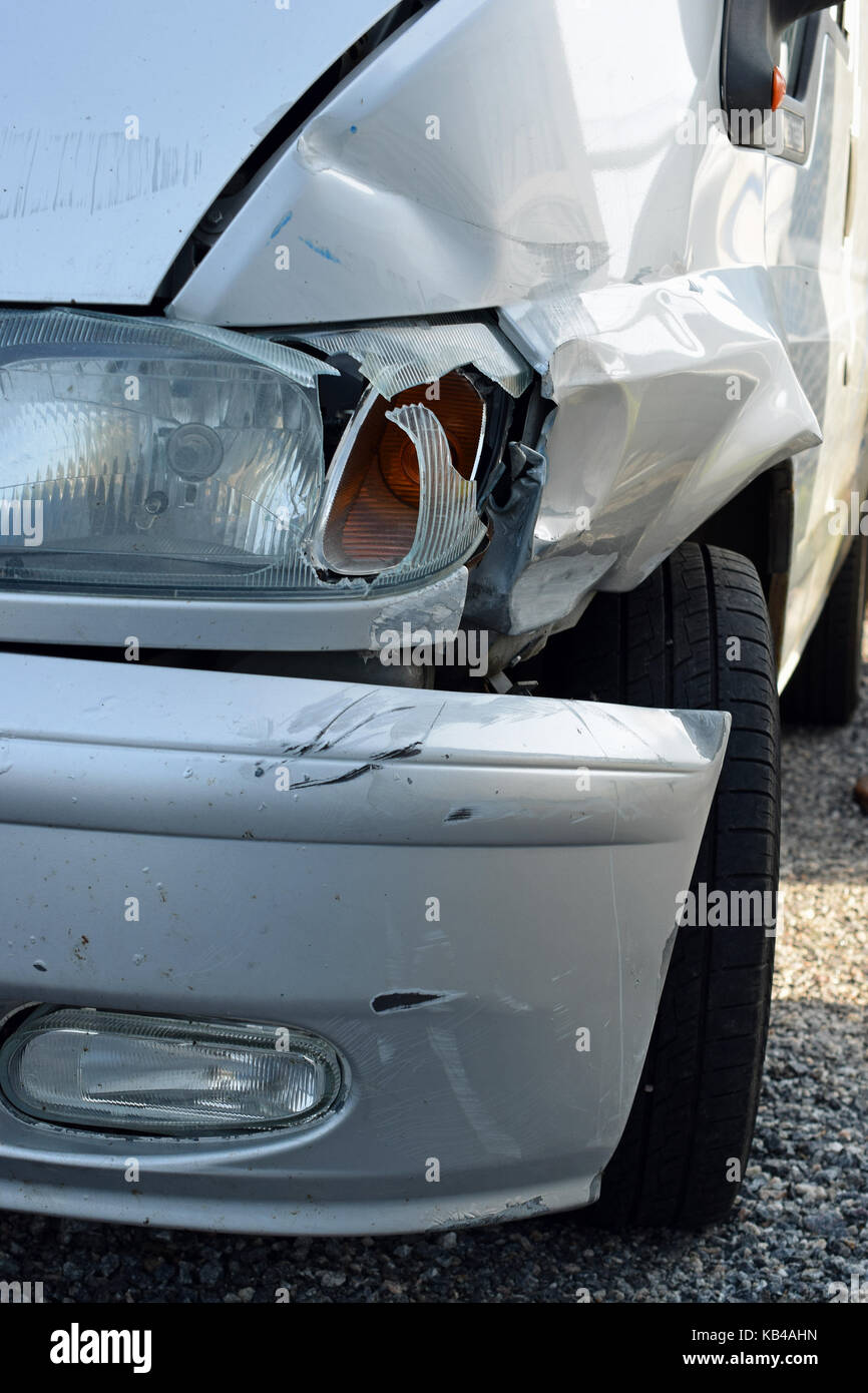 Damaged silver van after accident. Vertical close up image. Stock Photo