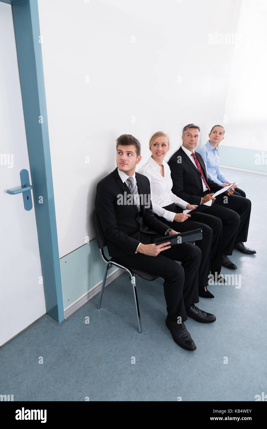 Group Of Applicants Sitting On Chair For Giving Interview In Office Stock Photo