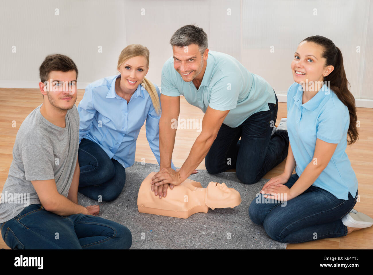 Mature Male Instructor Showing Cpr Training On Dummy To His Student Stock Photo