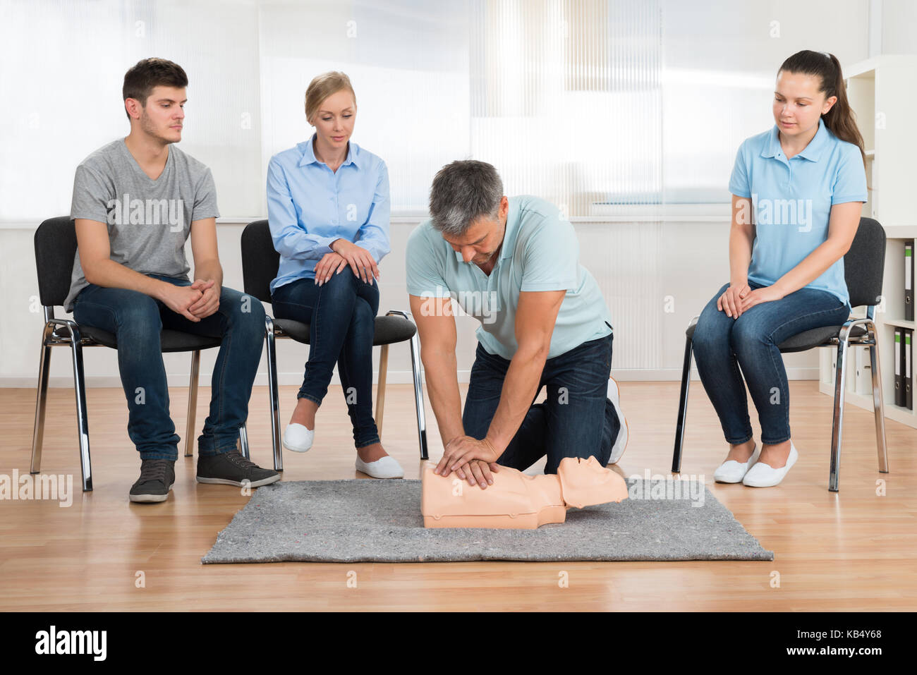 Male Instructor Teaching First Aid Cpr Technique To His Students Stock