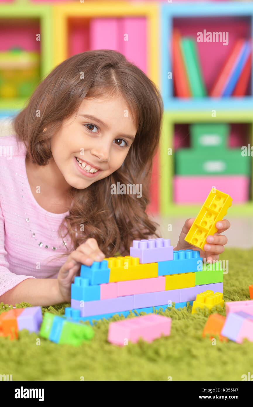 Cute girl playing with plastic blocks Stock Photo - Alamy