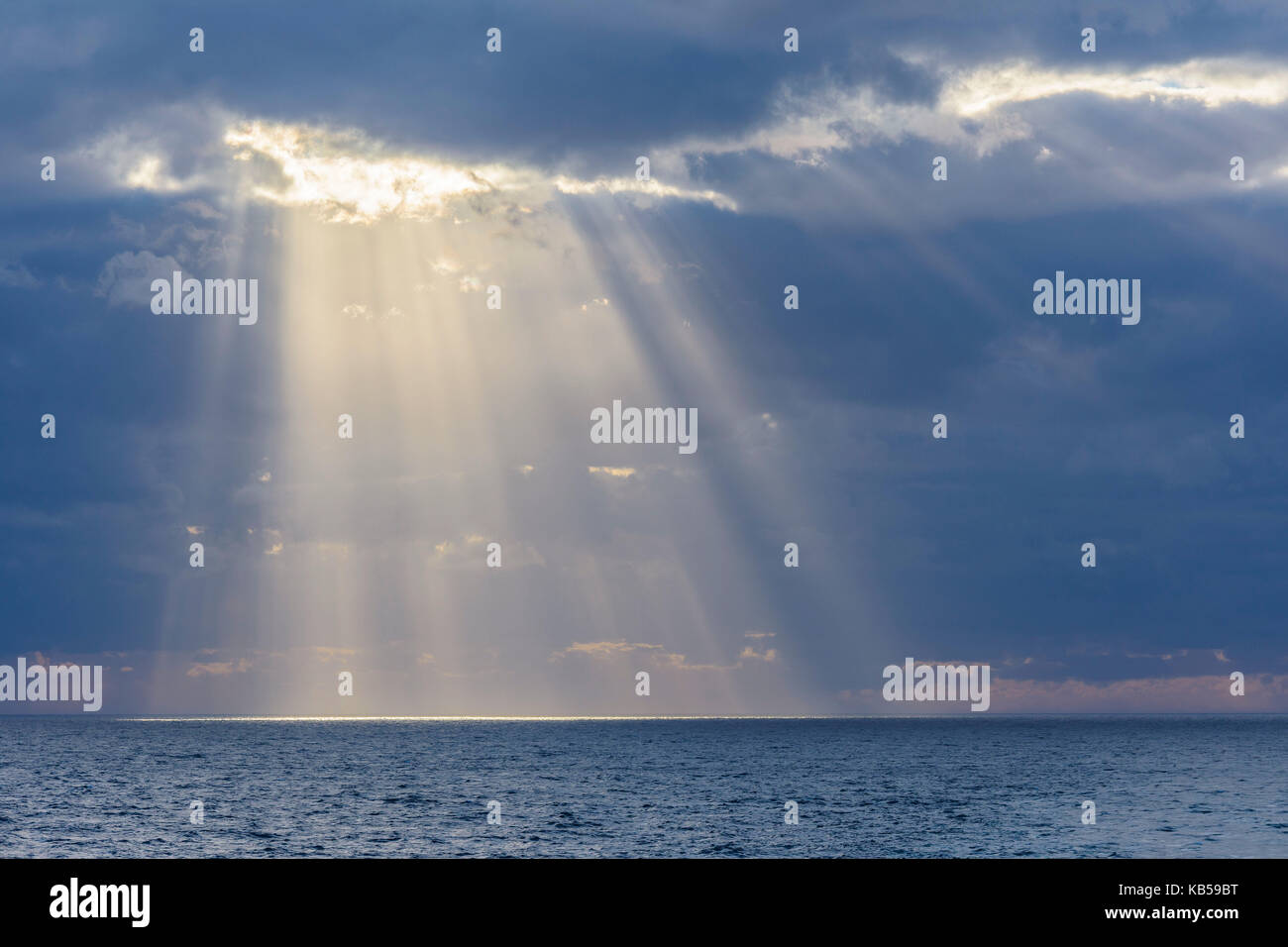 Sun breaks through the clouds with sunrays over sea, North Sea, United ...