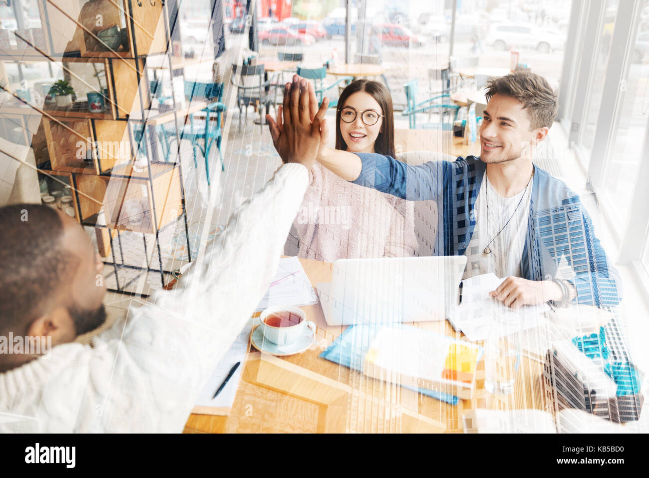 Smiling colleagues giving high five Stock Photo - Alamy