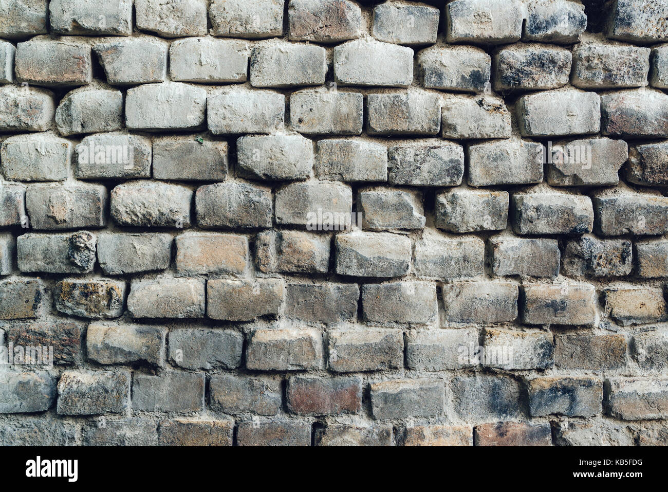 Rustic exterior brick wall surface as weather worn background Stock Photo