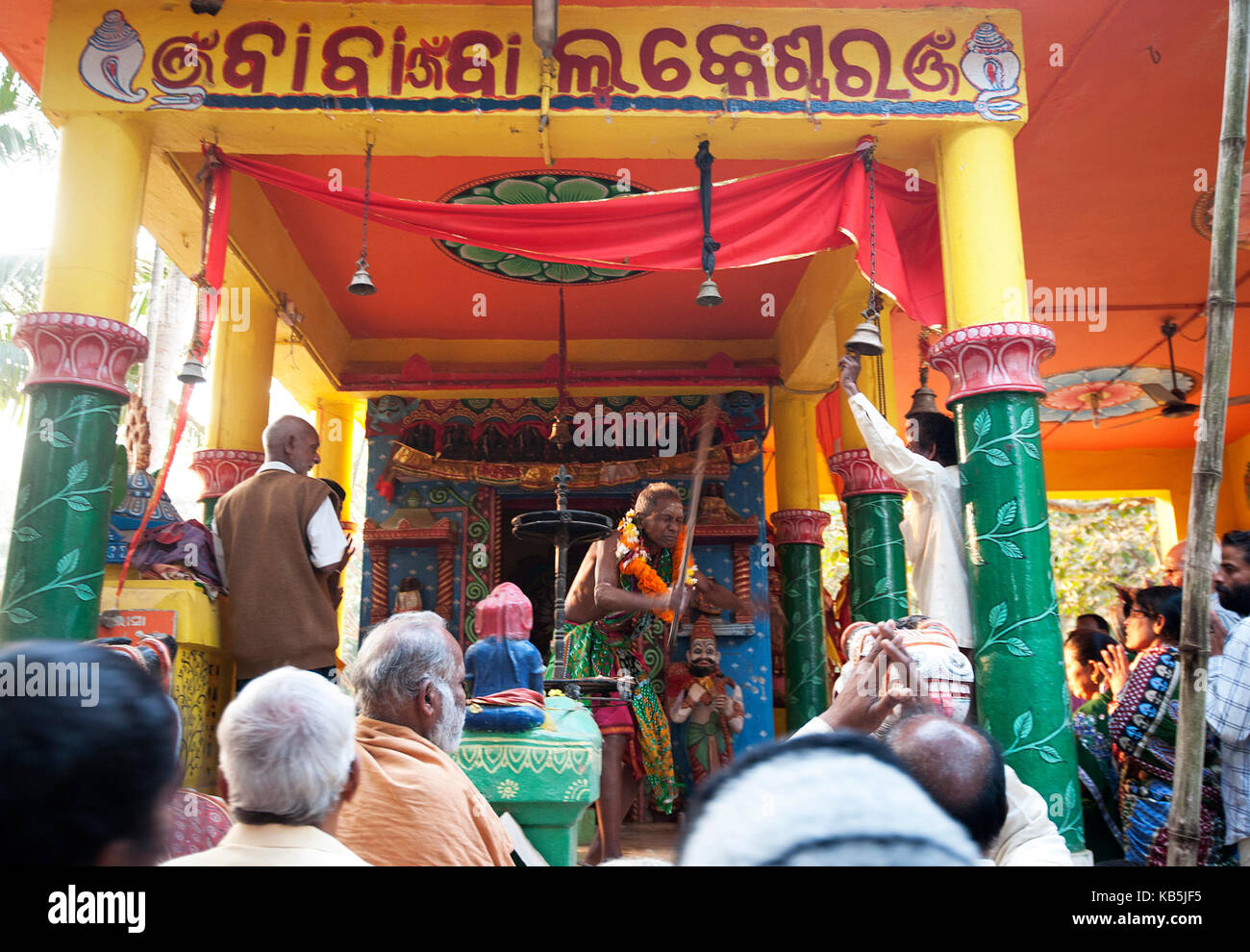 Shaman in highly altered state of consciousness performing ritual for villagers gathered in Hindu temple, Odisha, India Stock Photo