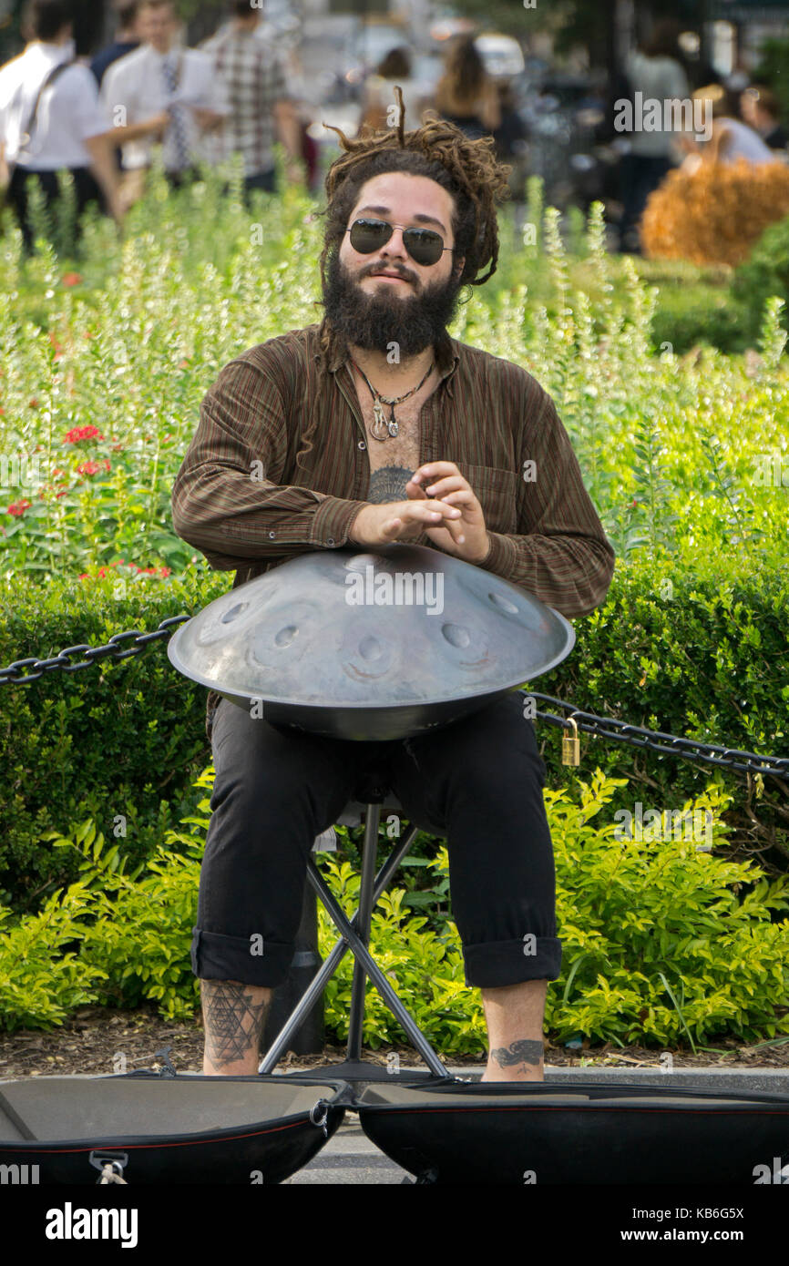 A busker with dreadlocks playing a steel drum in Washington Square Park in Greenwich Village, New York City. Stock Photo
