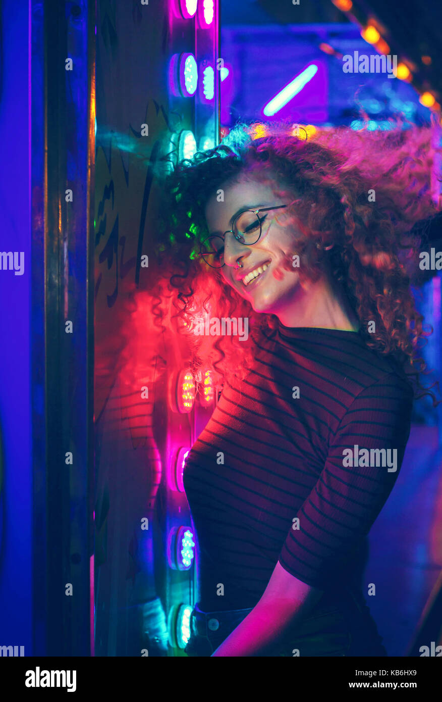Portrait of a young woman at night illuminated with color lights Stock Photo