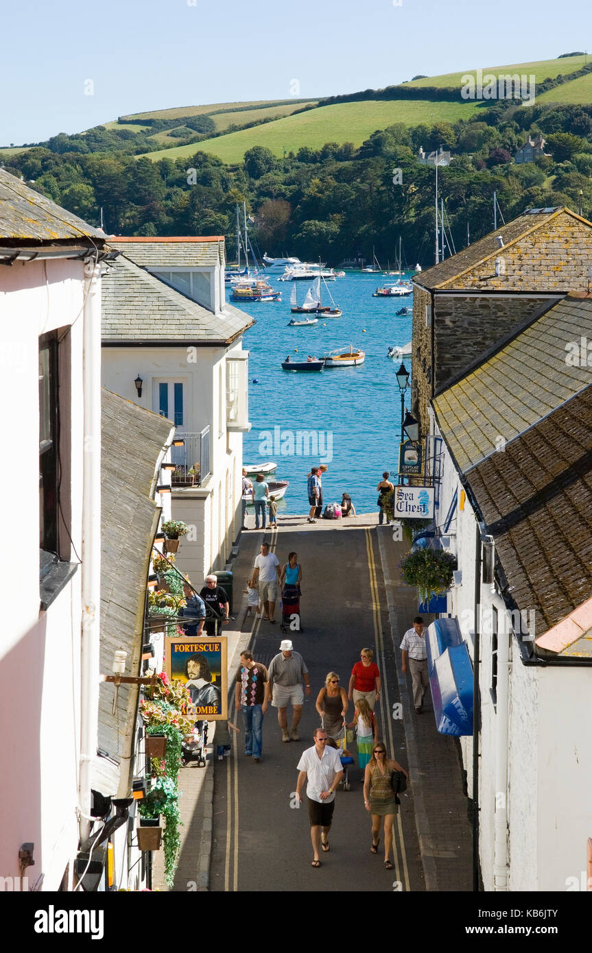 Looking down past the Fortescue Inn public house in  Salcombe - South Devon towards the estuary with tourists walking down the street. Seafood Coast Stock Photo