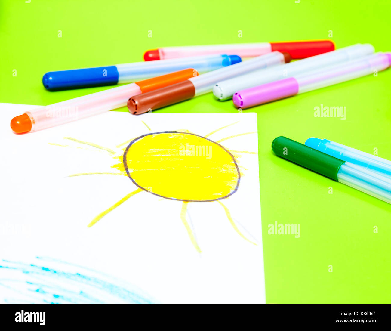 https://c8.alamy.com/comp/KB6R64/color-markers-with-childs-drawing-of-the-sun-on-a-table-KB6R64.jpg