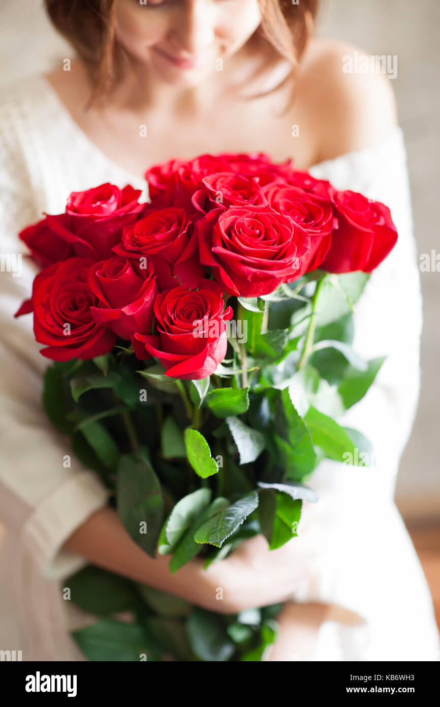 beautiful young girl with big red roses bouquet Stock Photo - Alamy