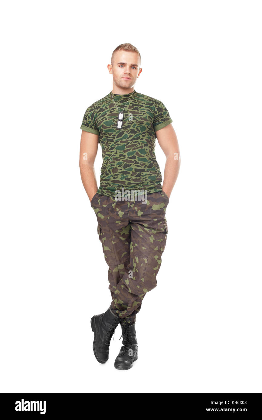 Full length portrait of young army soldier standing with hands in pockets isolated on white background Stock Photo
