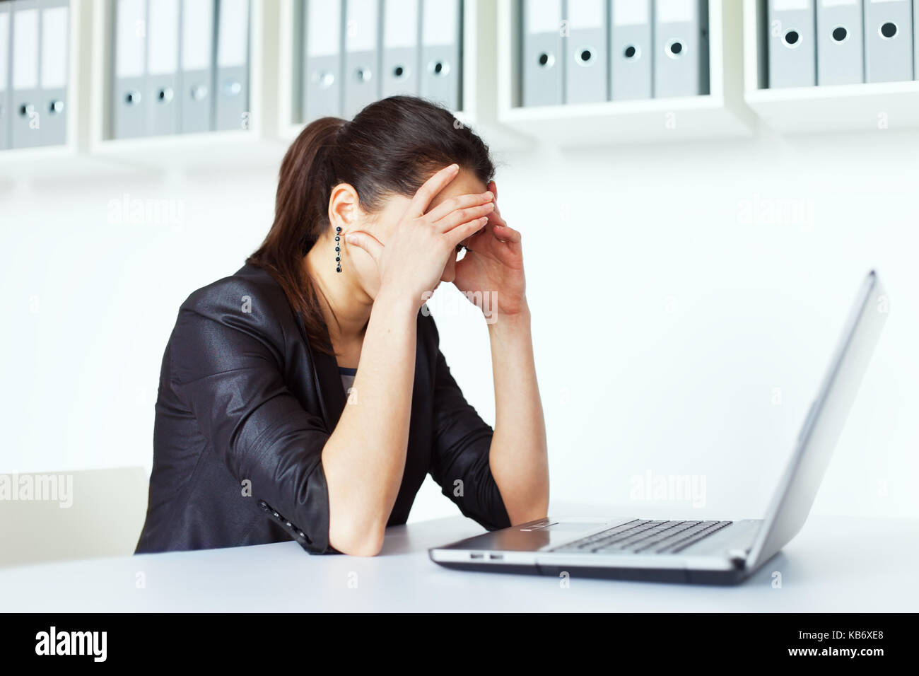 Portrait of tired young business woman with laptop at the office Stock ...