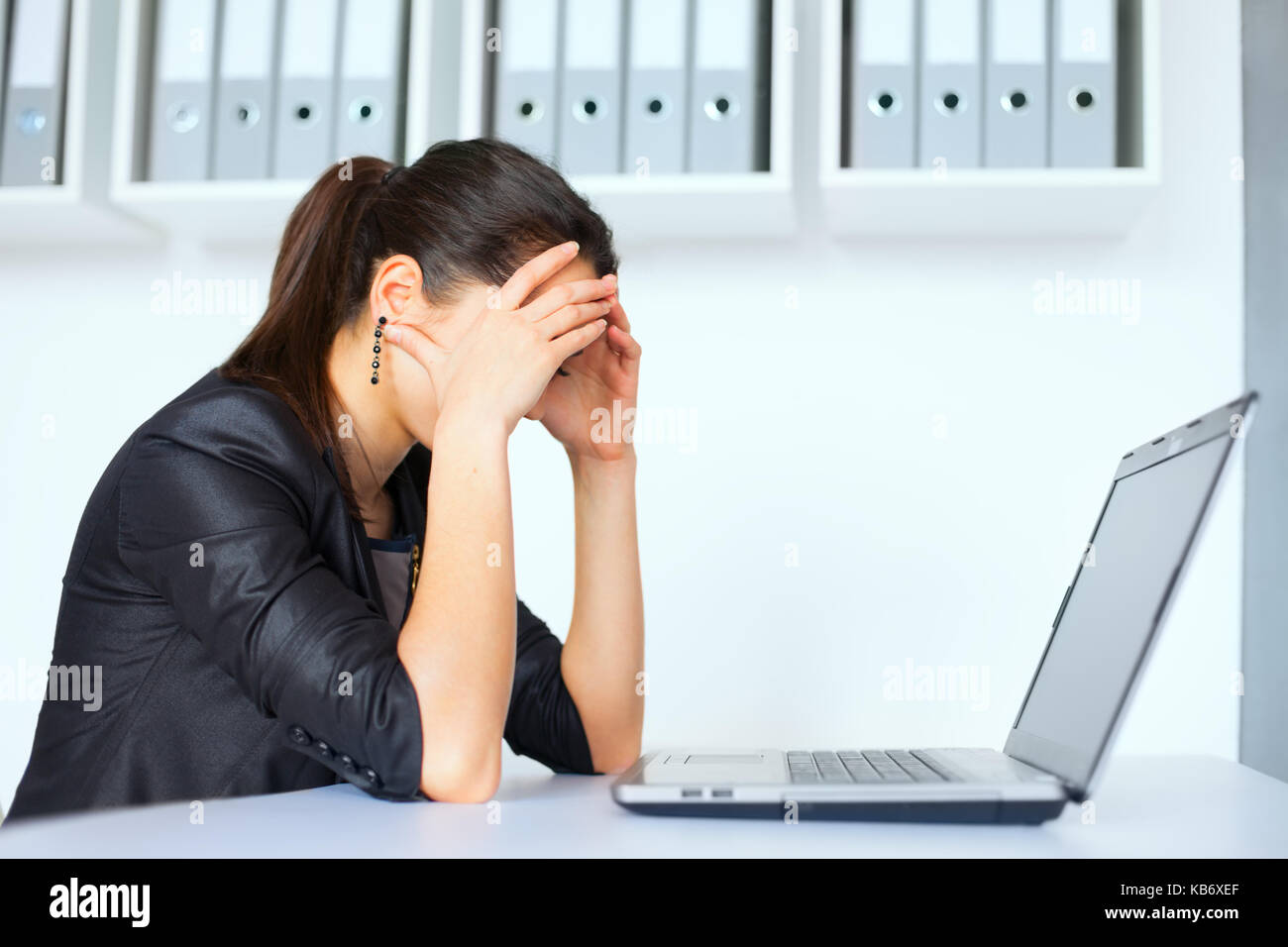 Portrait of tired young business woman with laptop at the office Stock ...