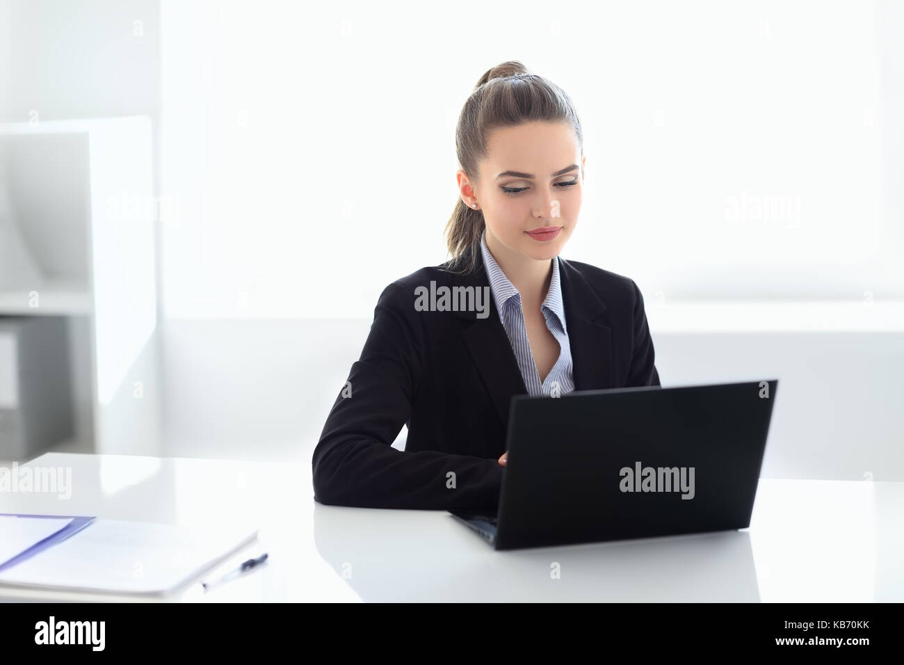 Portrait of young beautiful business woman with laptop in the office ...