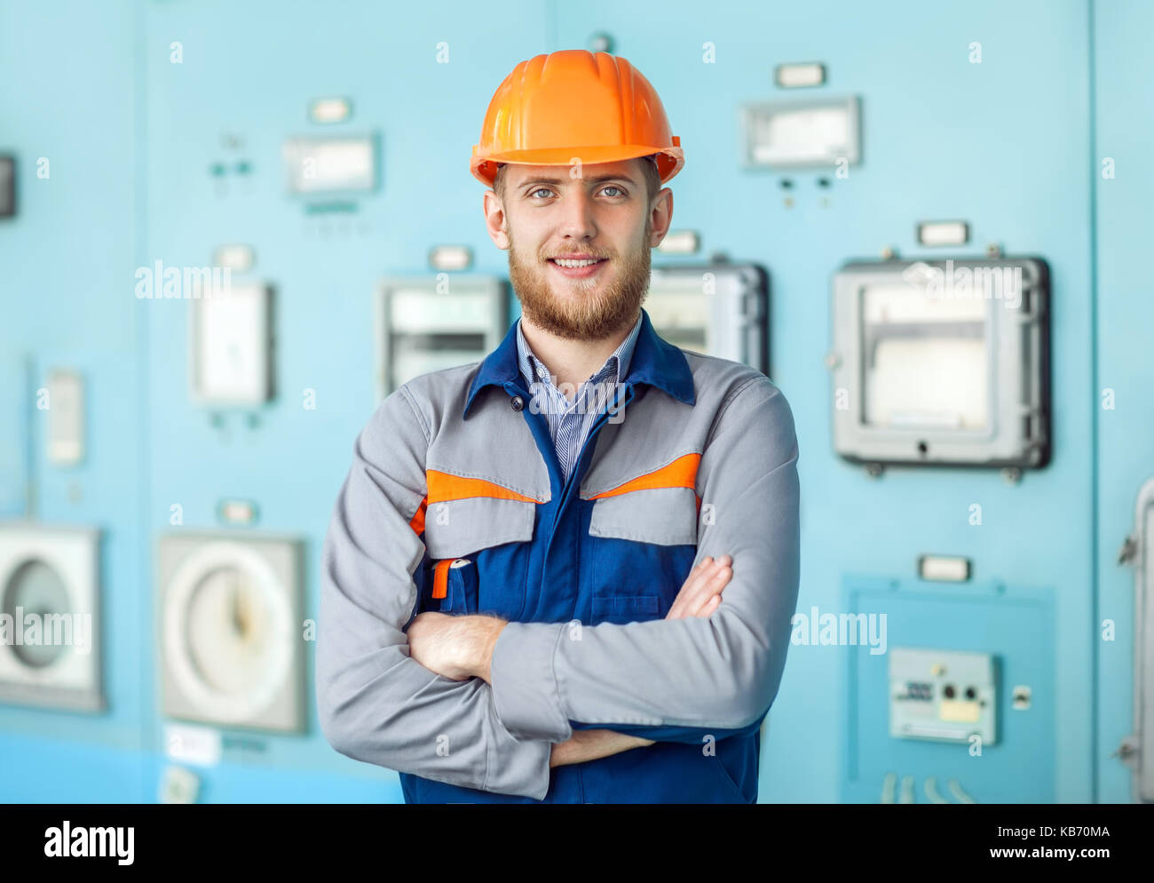 Portrait of young happy engineer at control room. Crossed arms Stock Photo