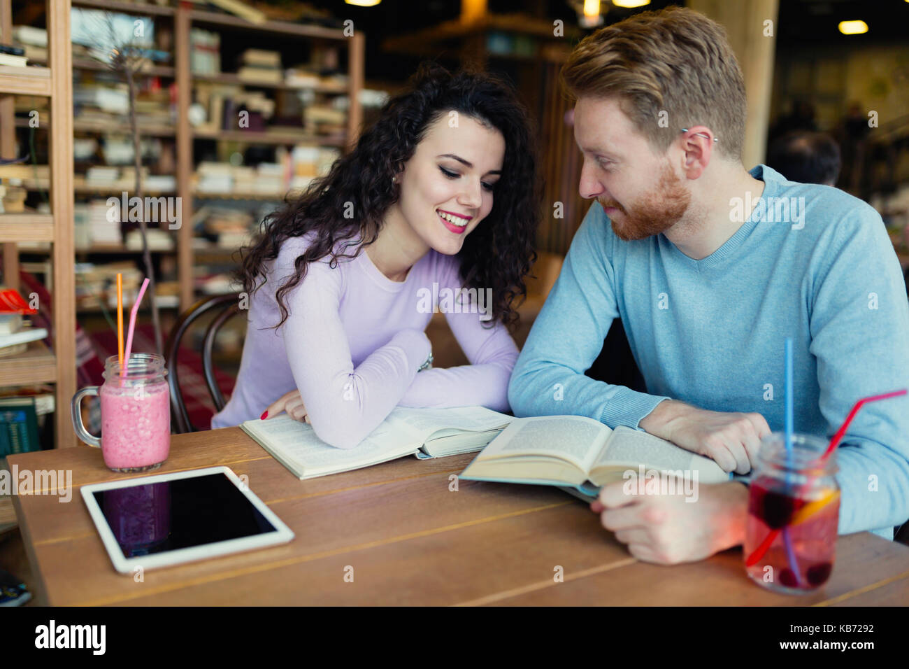 Young students spending time in coffee shop reading books Stock Photo