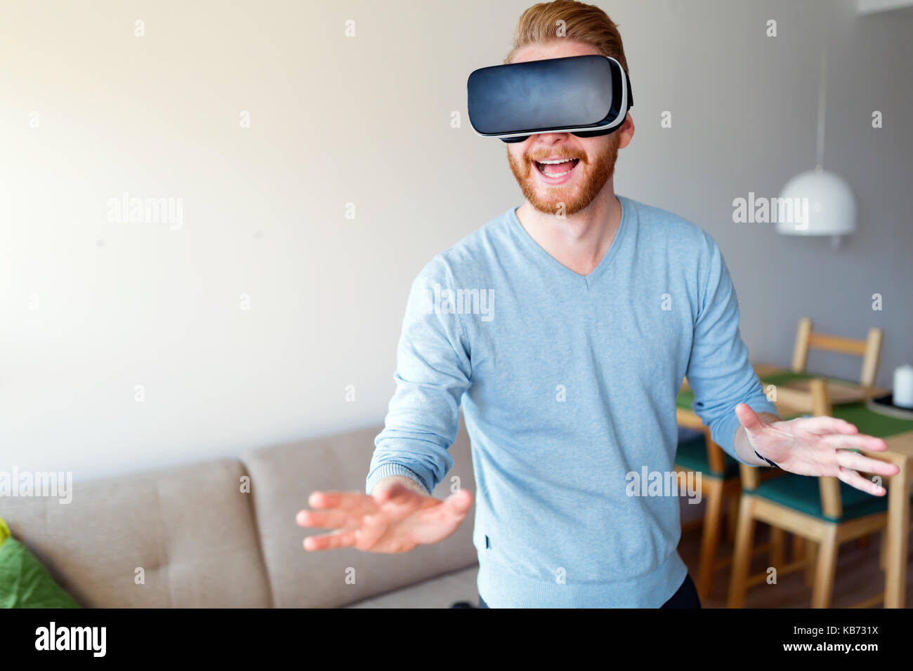Man wearing virtual reality headset at home Stock Photo - Alamy