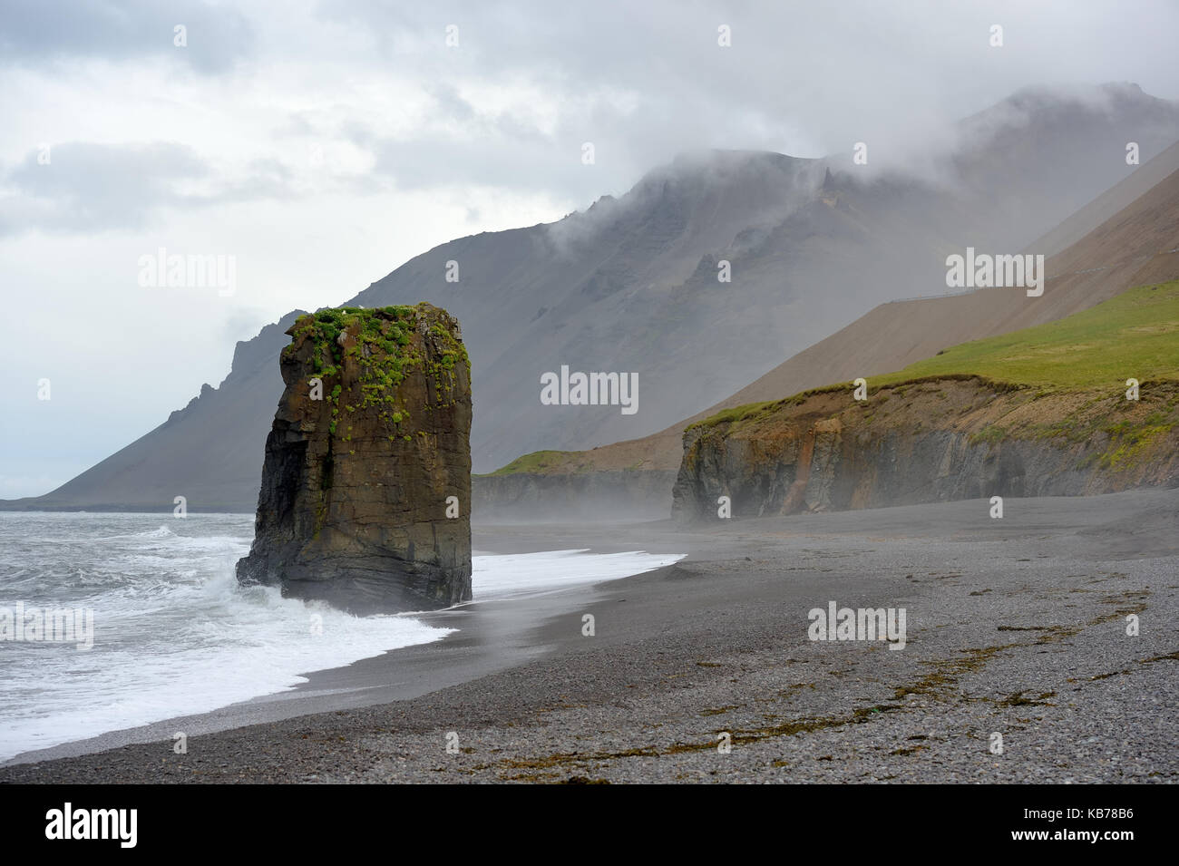 Stapavik Gravel beach with a high rock on a cloudy day, Iceland Stock Photo
