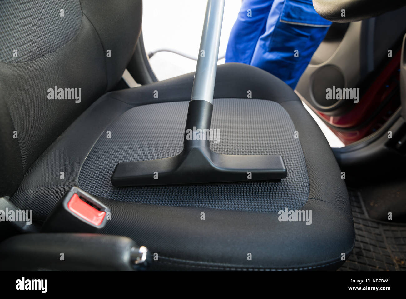 Cropped image of man vacuuming car seat with vacuum cleaner Stock Photo