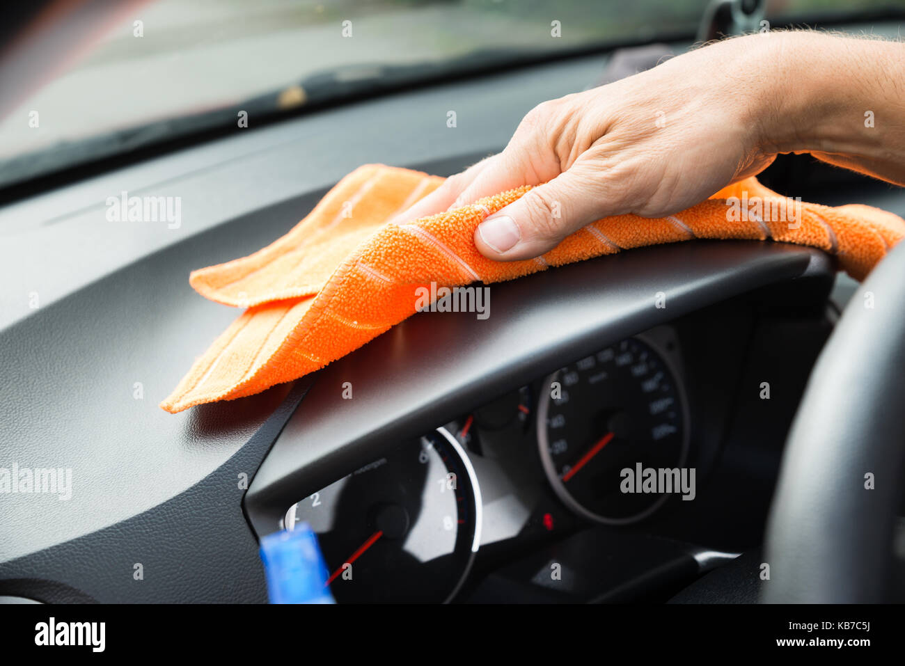 Cropped image of mature male worker cleaning car dashboard Stock Photo