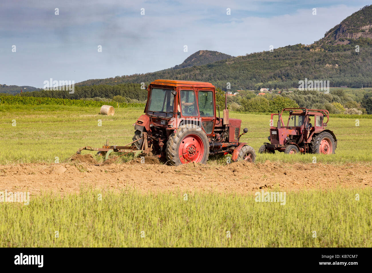 Old tractor working on the field Stock Photo - Alamy