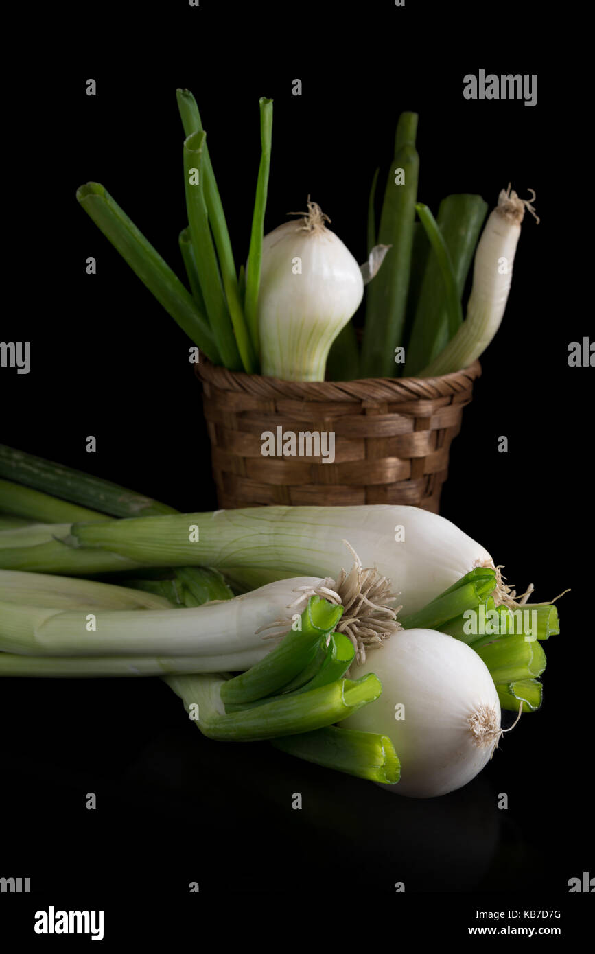 fresh spring onions in basket on black background Stock Photo - Alamy