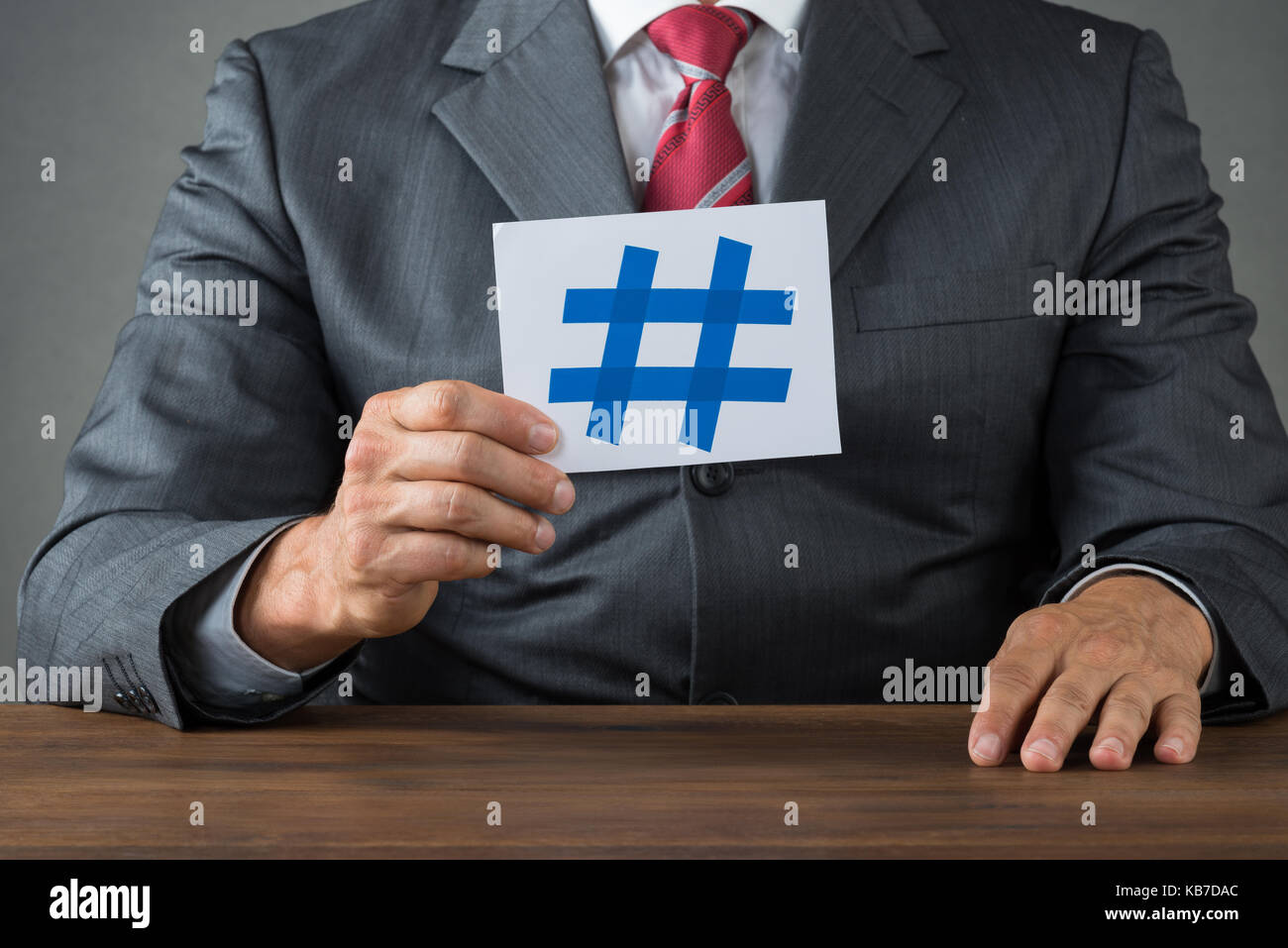 Midsection of businessman showing hash sign on paper at desk Stock ...