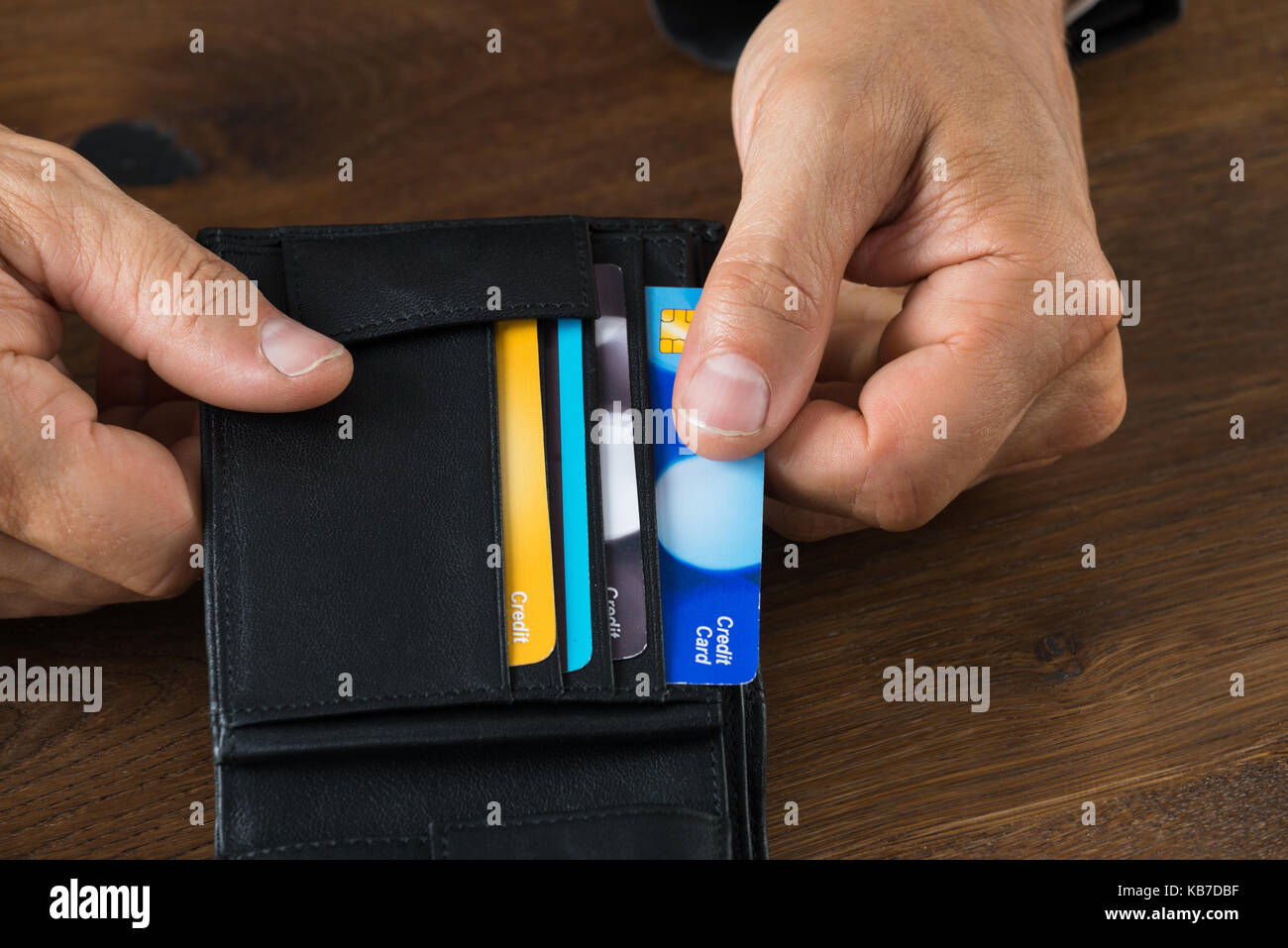 Cropped image of businessman showing credit card in wallet at desk Stock Photo