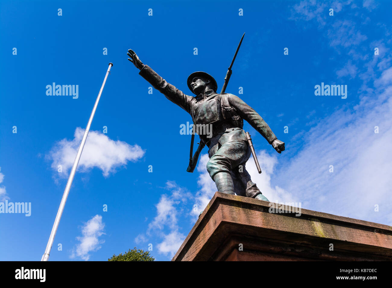War memorial. Bronze statue of a ww1 soldier reaching forward, bayonet rifle on his back. Castle Grounds, Bridgnorth, Shropshire, UK. Stock Photo