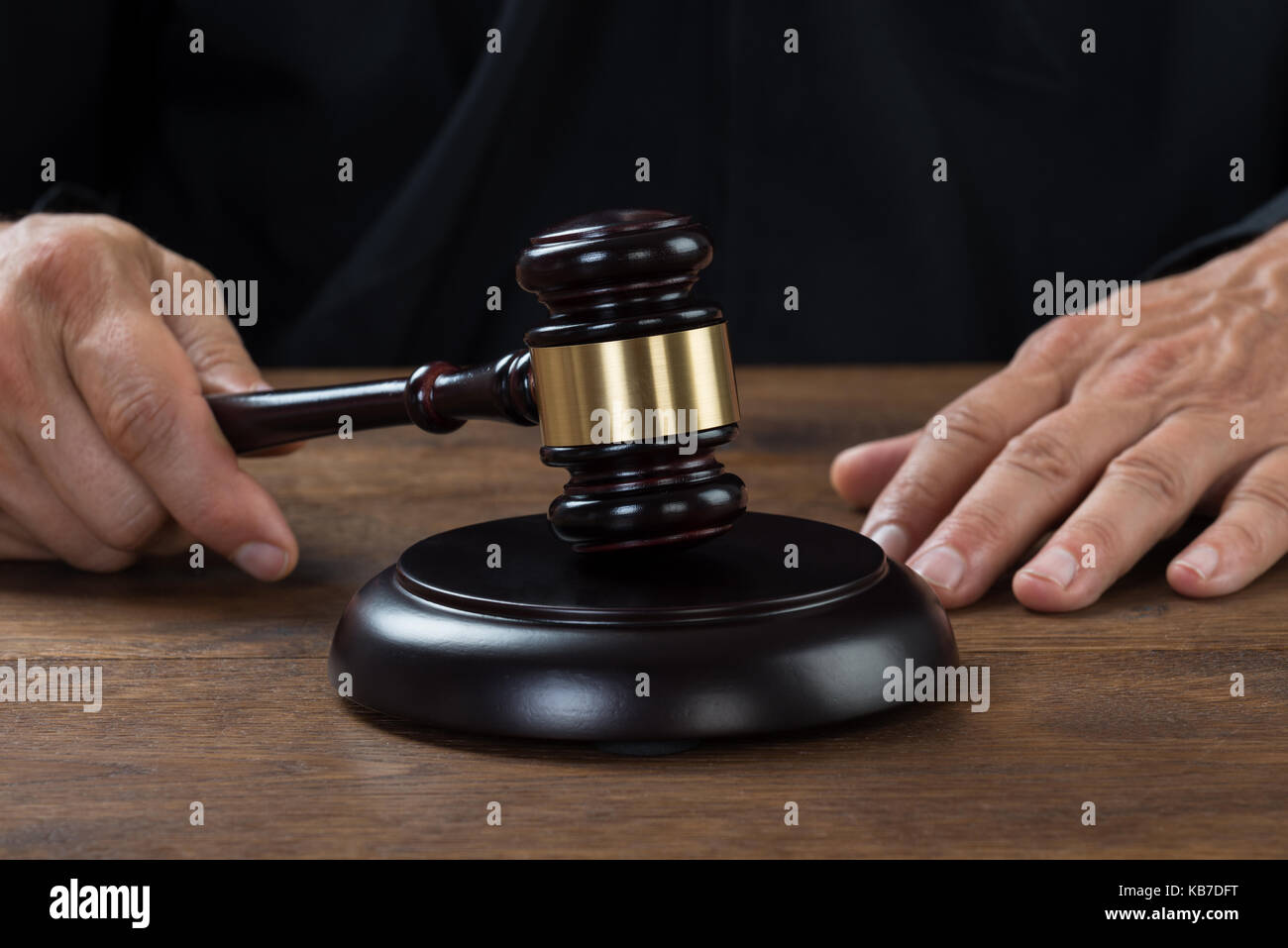 Cropped image of male judge striking the gavel at table Stock Photo Alamy