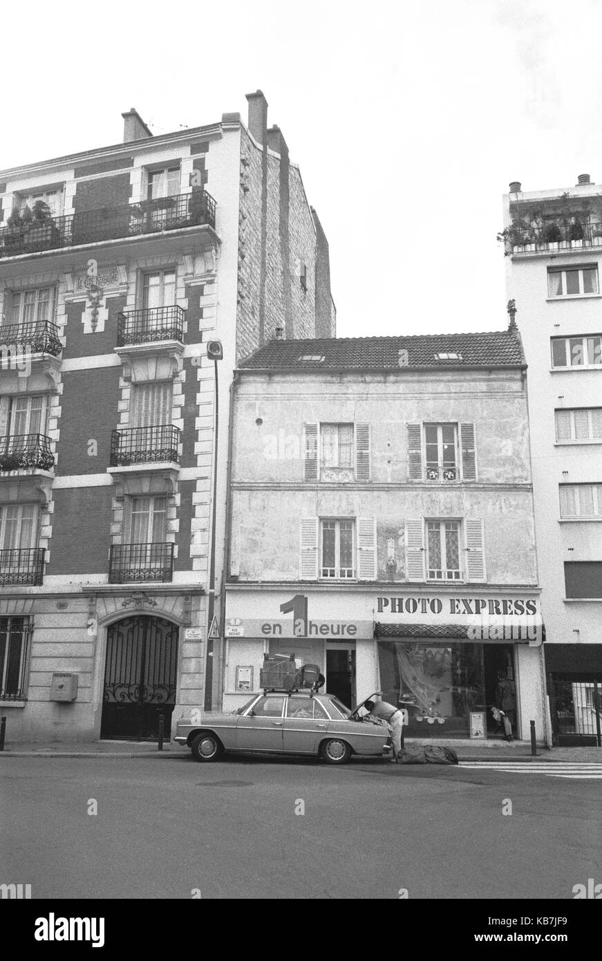 PARIS STREET PHOTOGRAPHY - MAN LOADING HIS CAR FOR THE SUMMER HOLIDAY- PARIS PEOPLE- PARIS SHOP-FRENCH VINTAGE- FRANCE -SILVER FILM© Frédéric BEAUMONT Stock Photo