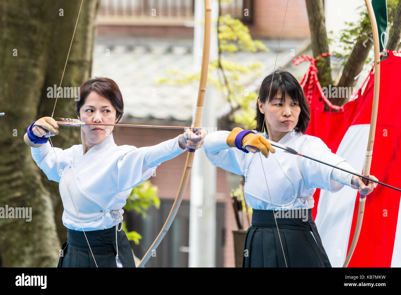 Japan, Osaka, Tada. Genjo parade and festival. Archery contest, two women, midadults, with bows