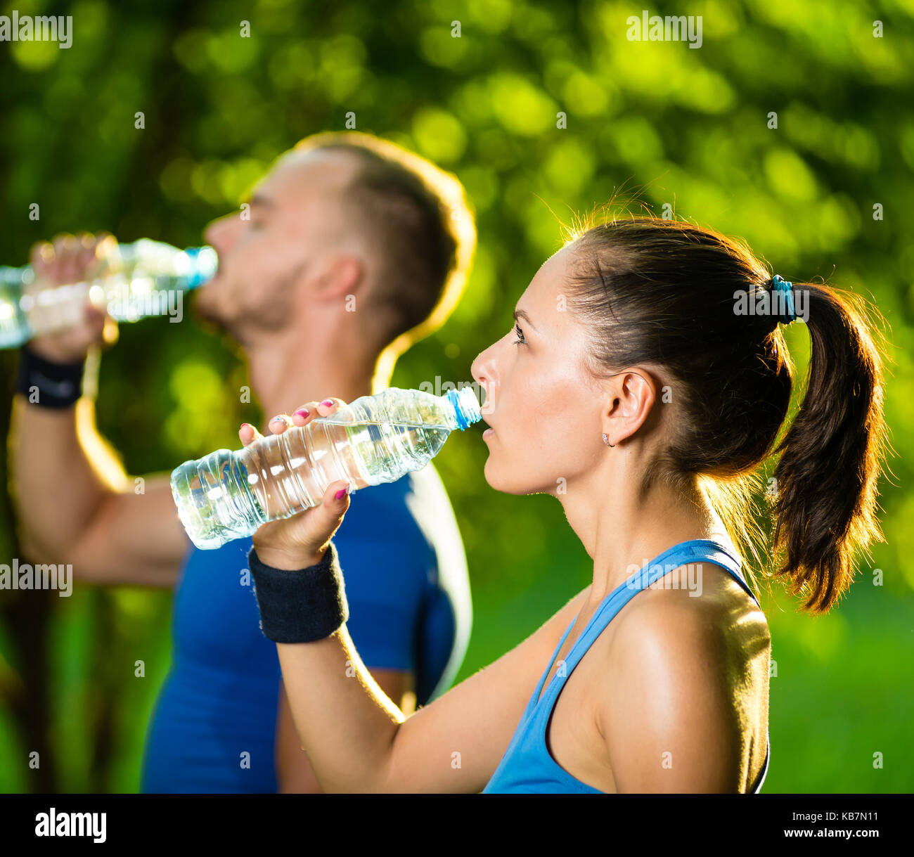 Man and woman drinking water from bottle after fitness sport exercise Stock Photo