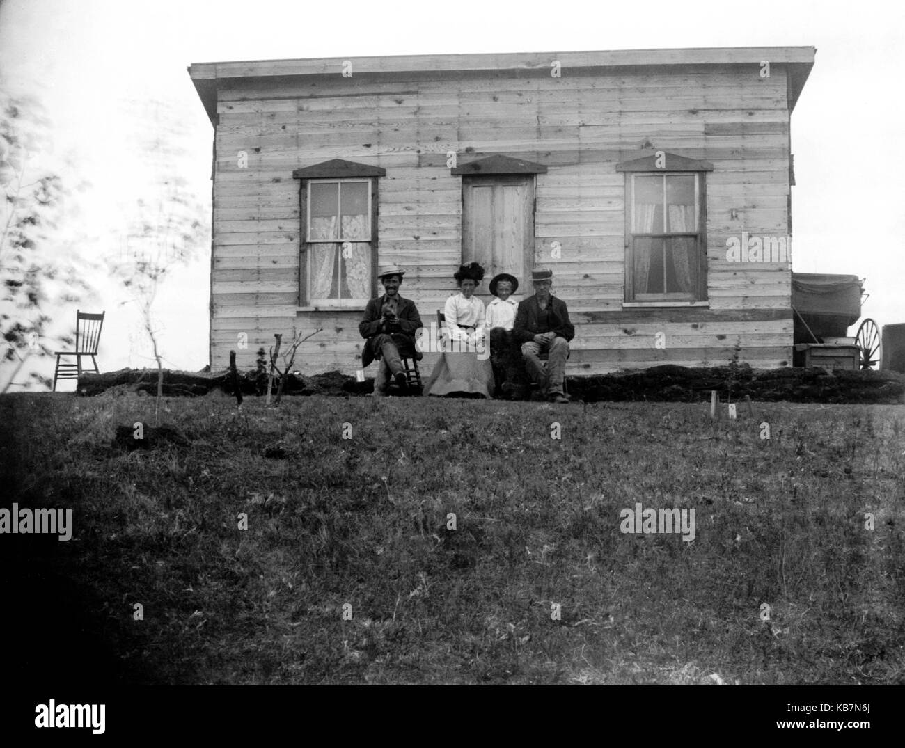 AJAXNETPHOTO. 1903. CANADA, EXACT LOCATION UNKNOWN. - GROUP POSE FOR THE CAMERA IN FRONT OF A WOODEN HOUSE. PHOTOGRAPHER:UNKNOWN © DIGITAL IMAGE COPYRIGHT AJAX VINTAGE PICTURE LIBRARY SOURCE: AJAX VINTAGE PICTURE LIBRARY COLLECTION REF:AVL 1973 Stock Photo