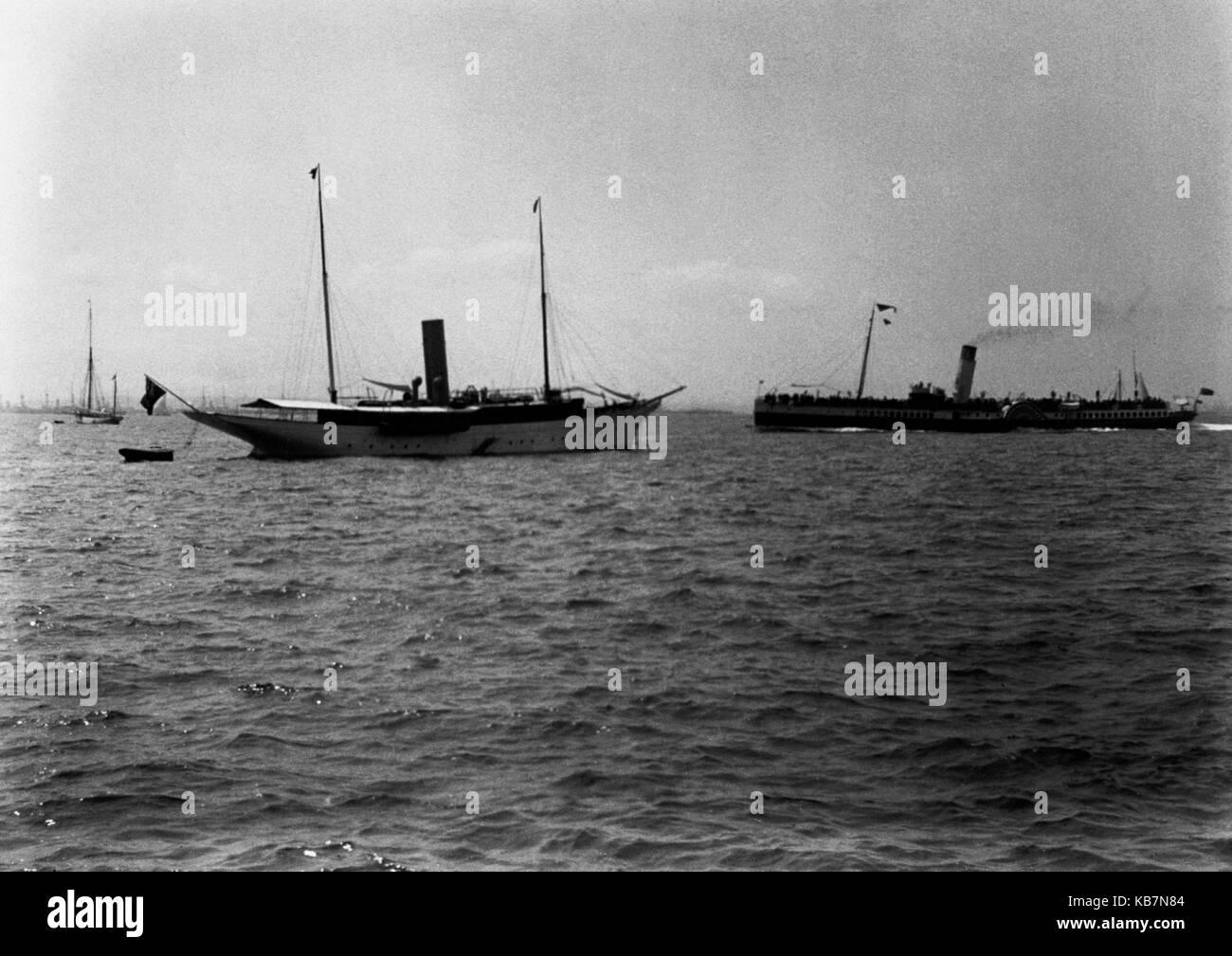 AJAXNETPHOTO. 1903. SOLENT, ENGLAND. - PADDLE STEAMER TRIPS - THE PADDLE STEAMER BALMORAL (RIGHT) PASSING A LARGE STEAM YACHT MOORED IN THE SOLENT. PHOTOGRAPHER:UNKNOWN © DIGITAL IMAGE COPYRIGHT AJAX VINTAGE PICTURE LIBRARY SOURCE: AJAX VINTAGE PICTURE LIBRARY COLLECTION REF:AVL 0573 Stock Photo