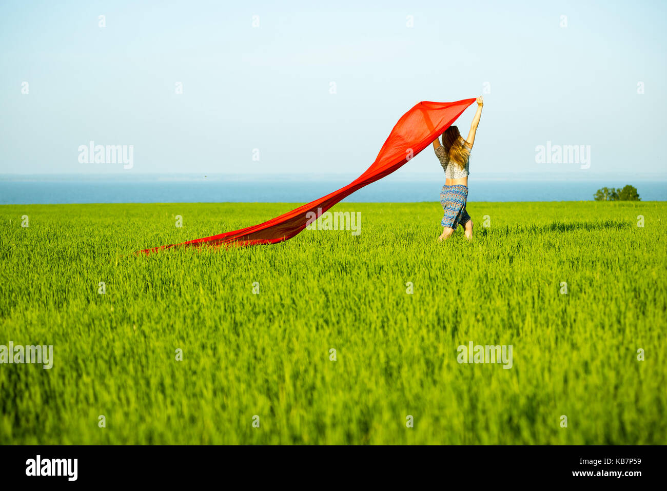 Young happy woman in wheat field with fabric. Summer lifestyle Stock Photo