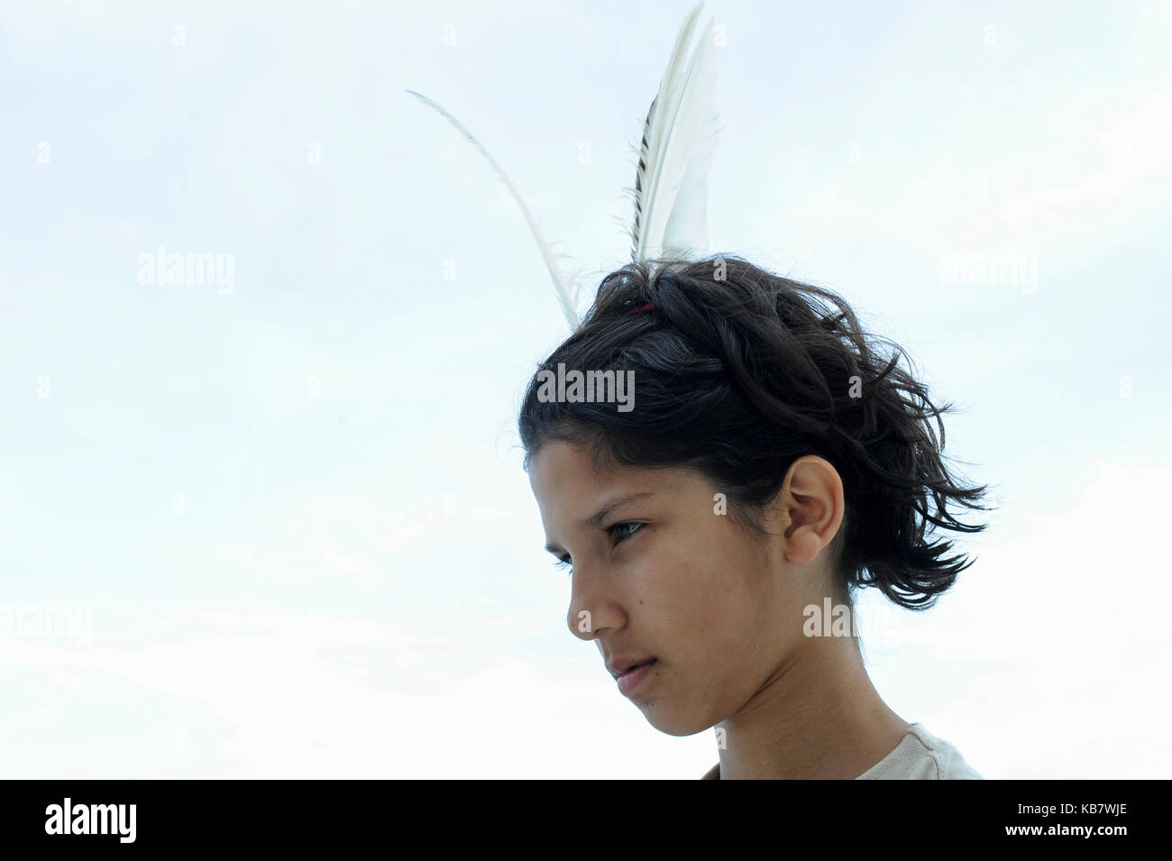 Germany, boy with white bird feather in hair playing something similar a red indian chieftain Stock Photo