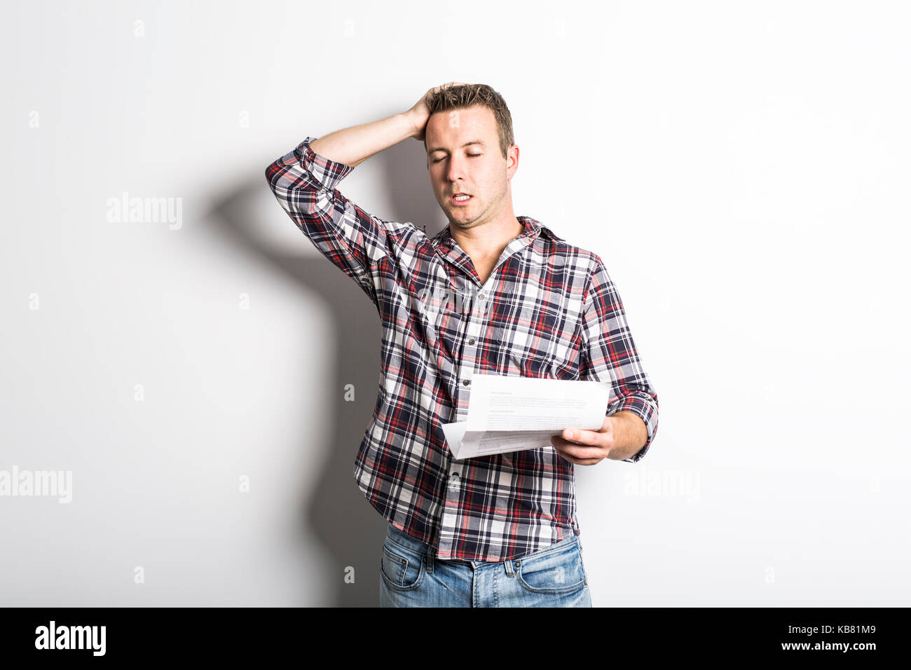 Shocked man holding some documents, isolated on gray background Stock ...