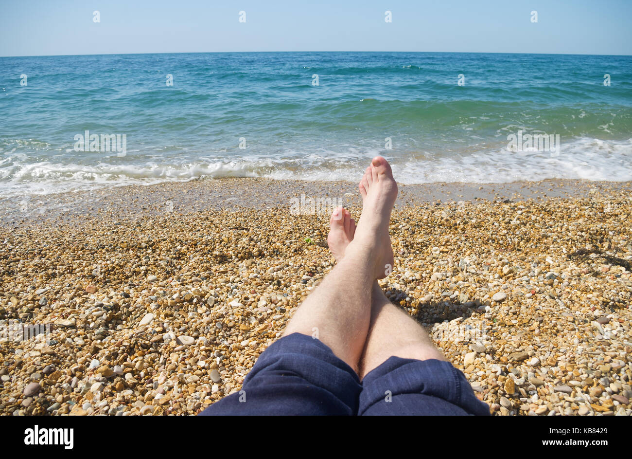 men's feet on the background of sea beach. A vacation at a seaside resort Stock Photo