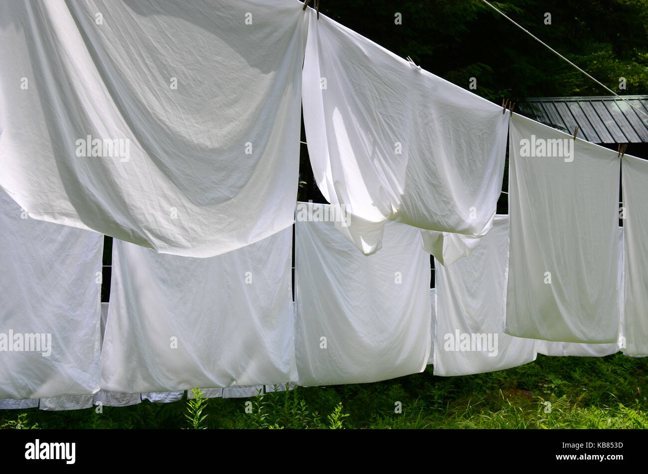 Bed sheets hanging on an outdoor clothes line. Stock Photo